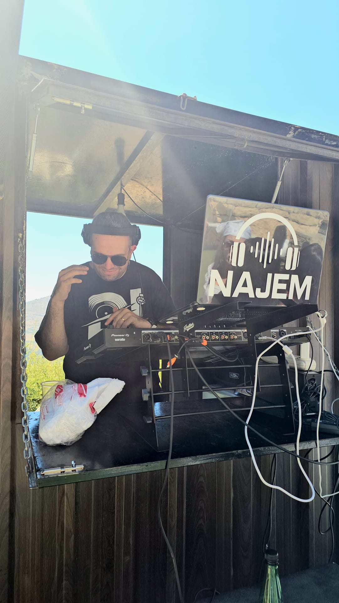 DJ Najem at his booth, crowd dancing in front of him